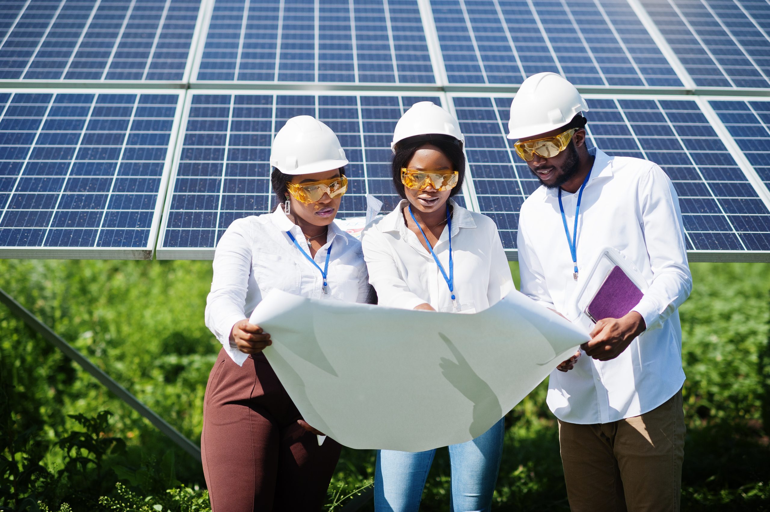 African american technician checks the maintenance of the solar panels. Group of three black engineers meeting at solar station.