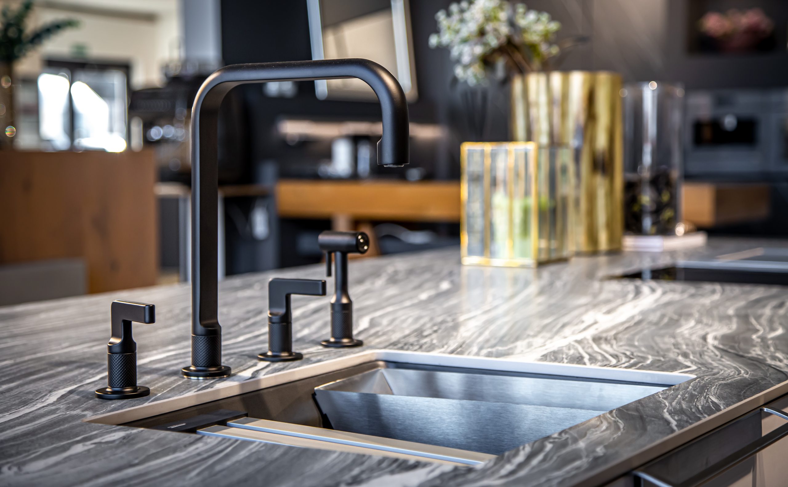 Black faucet with a steel sink in a stylish modern kitchen. Minimalism in refurbished apartment.